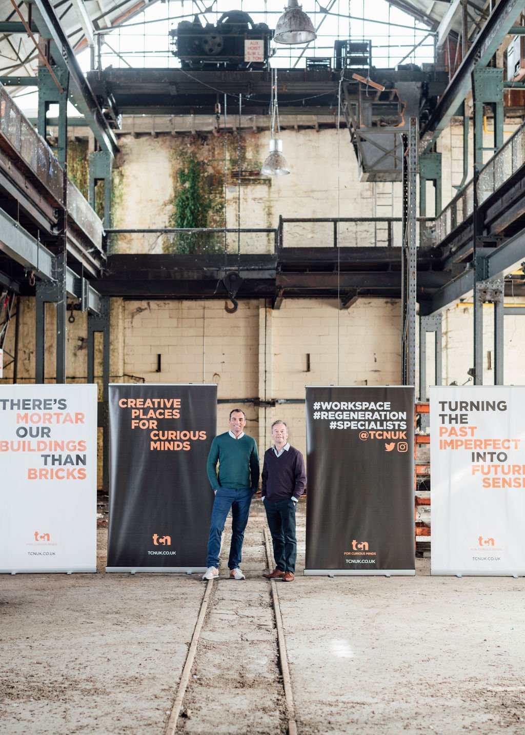 Newark Works Bath During Renovation With Two Men Stood In Space Between Banners