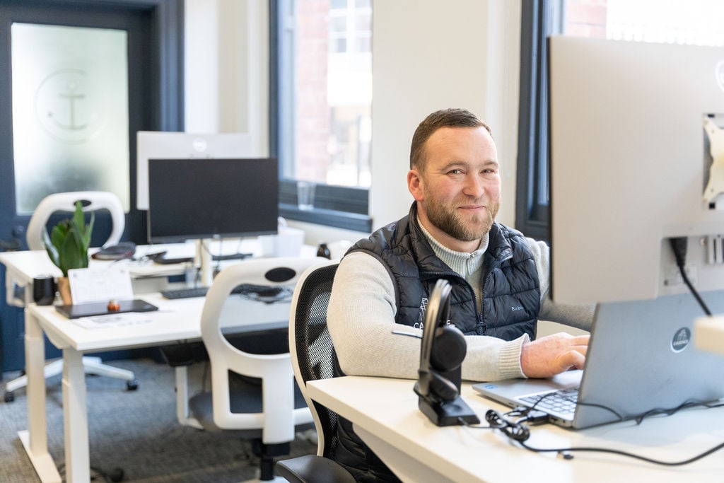 TCN Assay Studios Birmingham Member Pictured in Office Space Sat at Desk